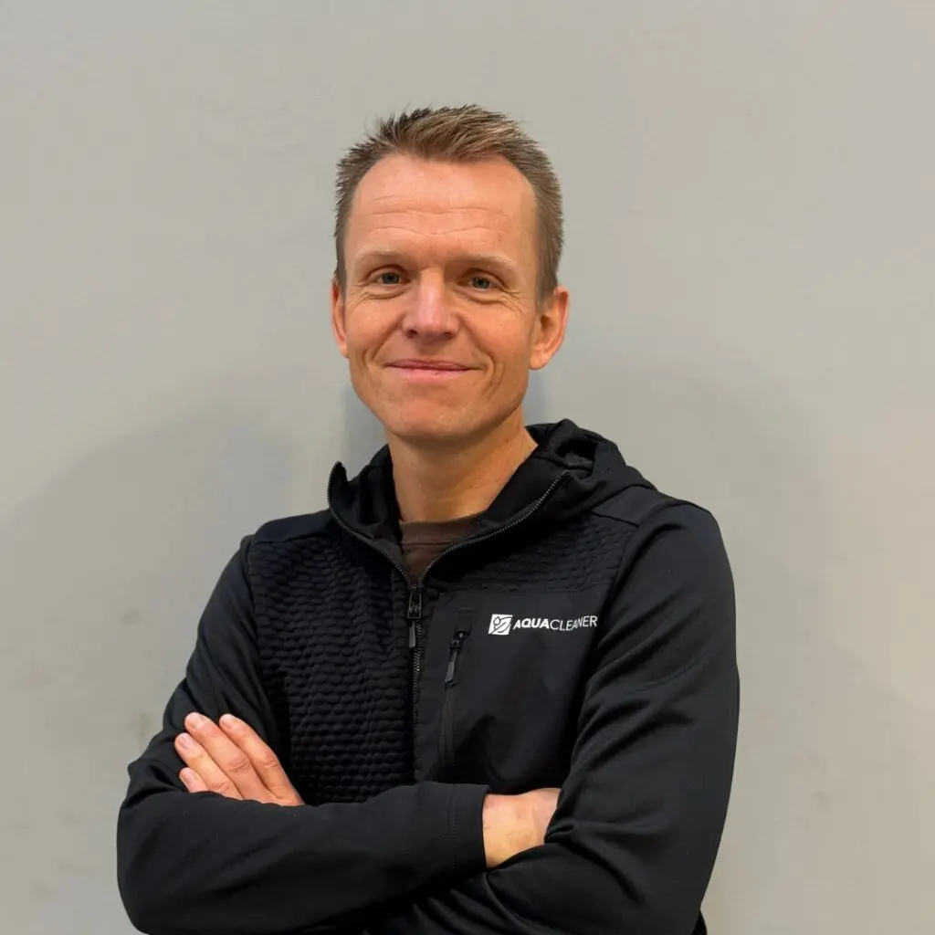 Claus Tobler fra Aqua Cleaner i sort firmatøj med logo. Ekspert i miljørigtig ukrudtsbekæmpelse med 105 grader varmt vand.