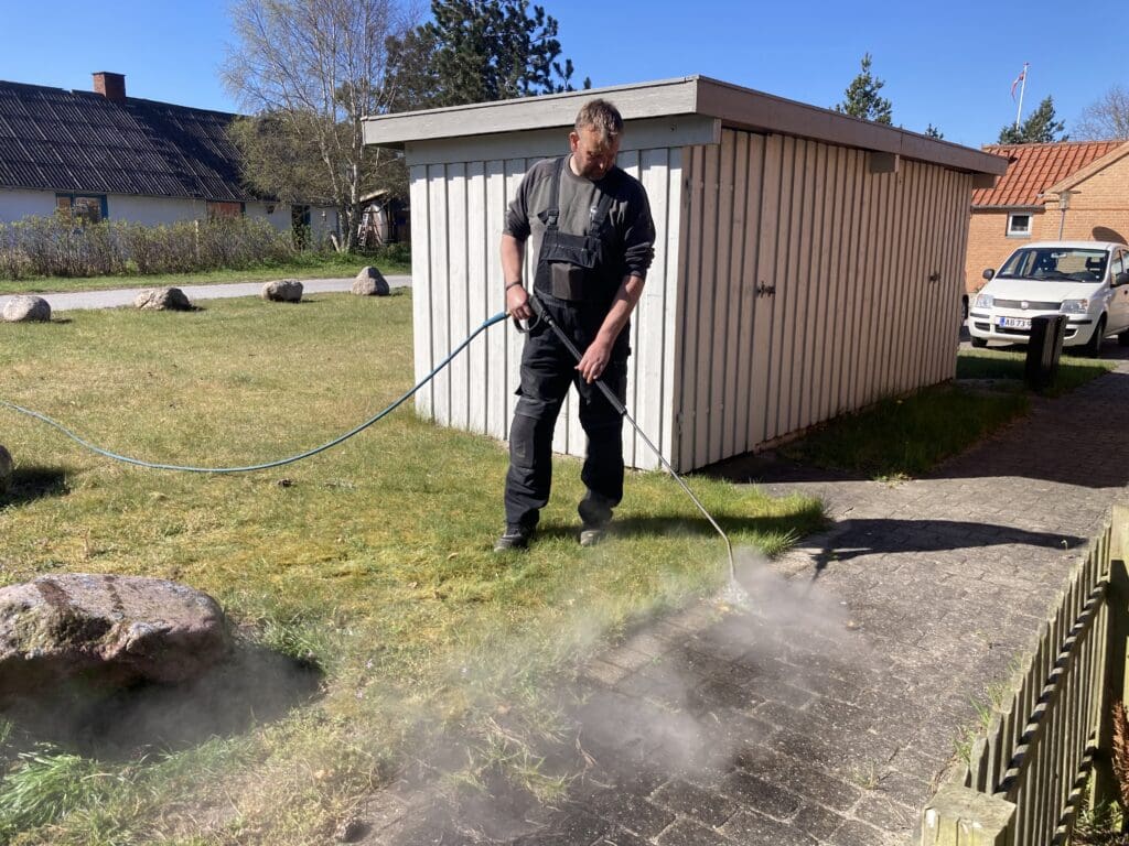 Professional weed control with 105-degree hot water between tiles using Greenheat Original.